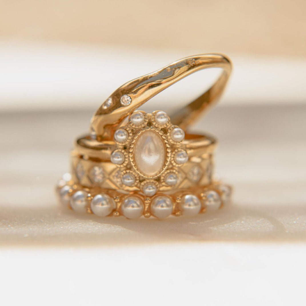 Gold pearl ring with oval freshwater pearl centre and small pearl accents in a waterproof setting