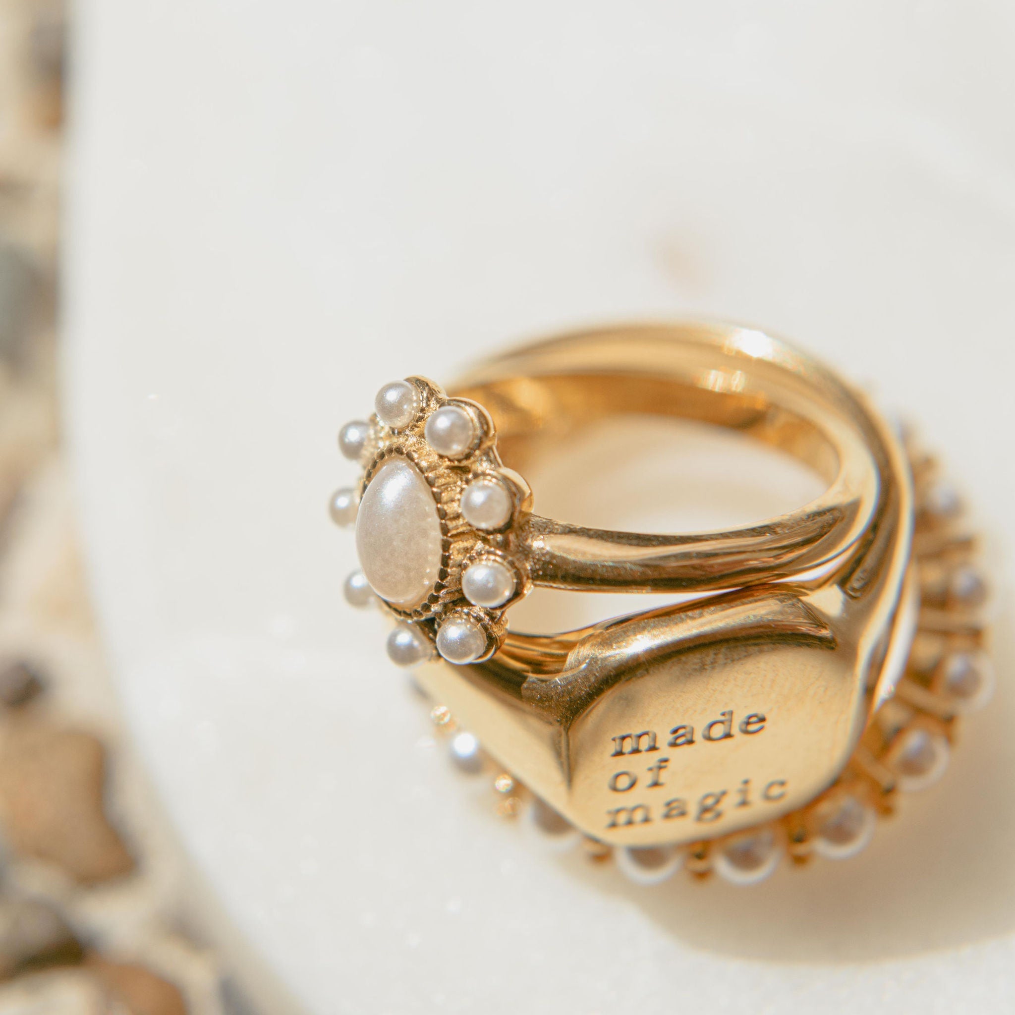 Gold pearl ring with oval freshwater pearl centre and small pearl accents in a waterproof setting