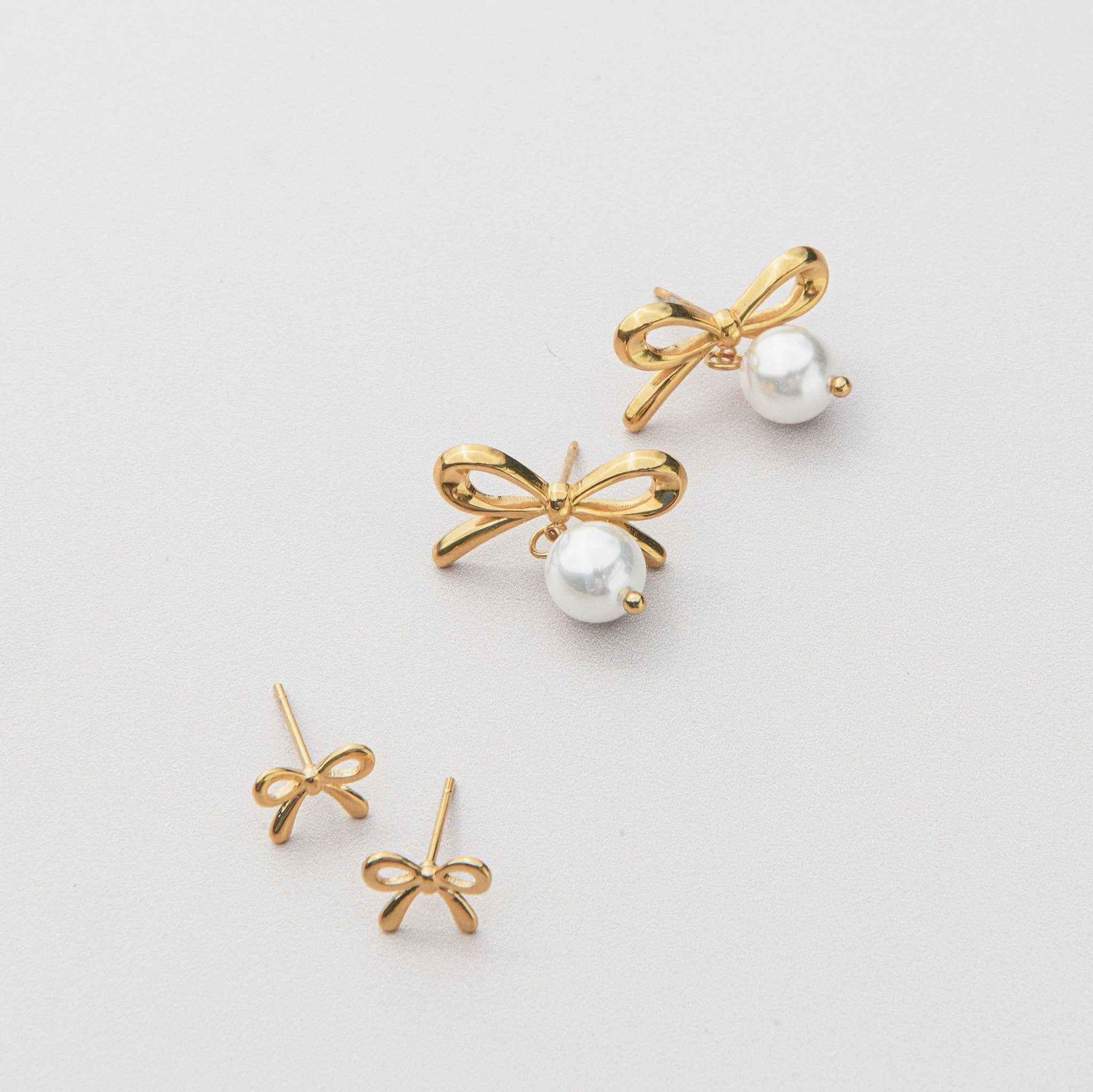 Gold pearl earrings with freshwater pearl drops and waterproof bow design