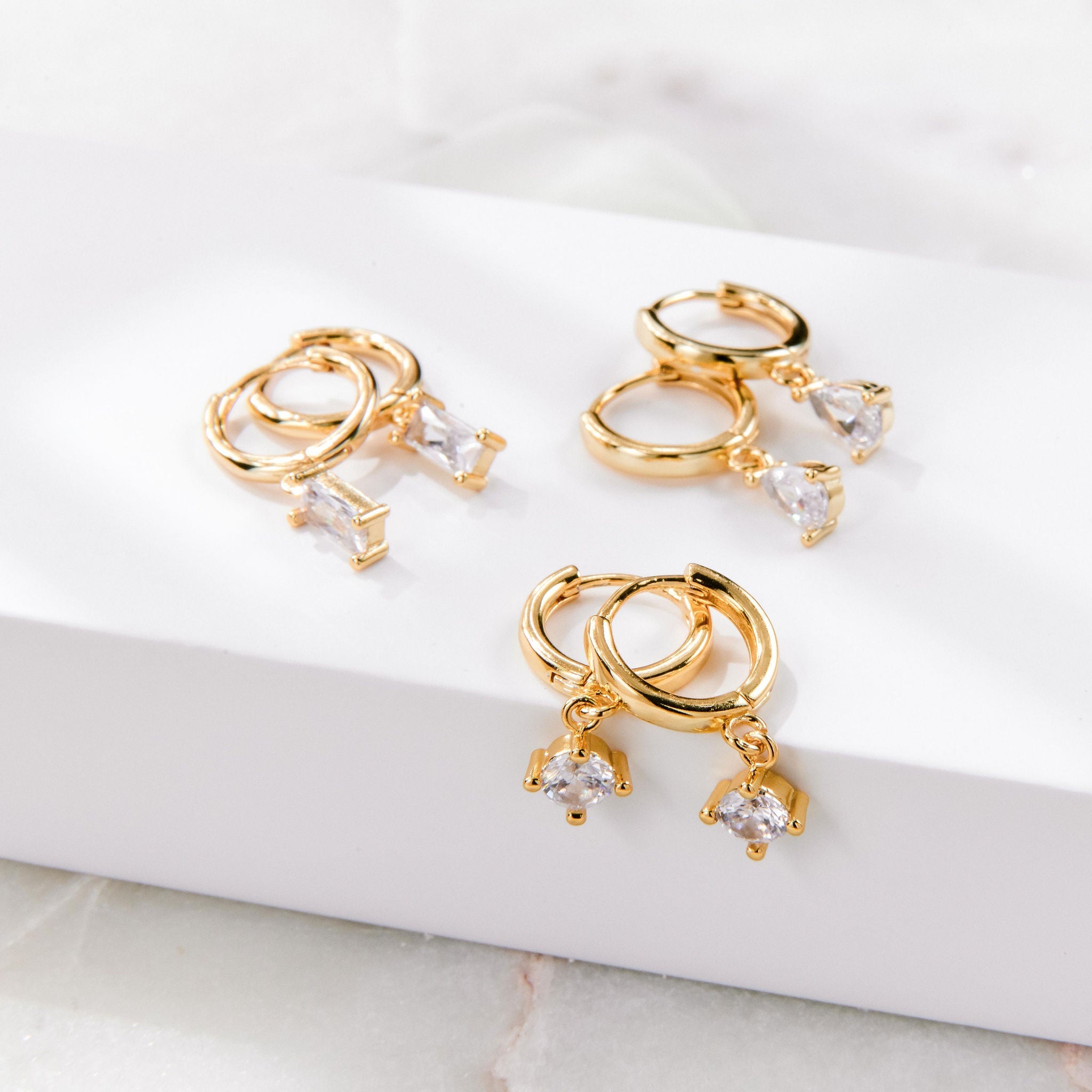 Gold huggie hoop earrings with pear-cut cubic zirconia drop