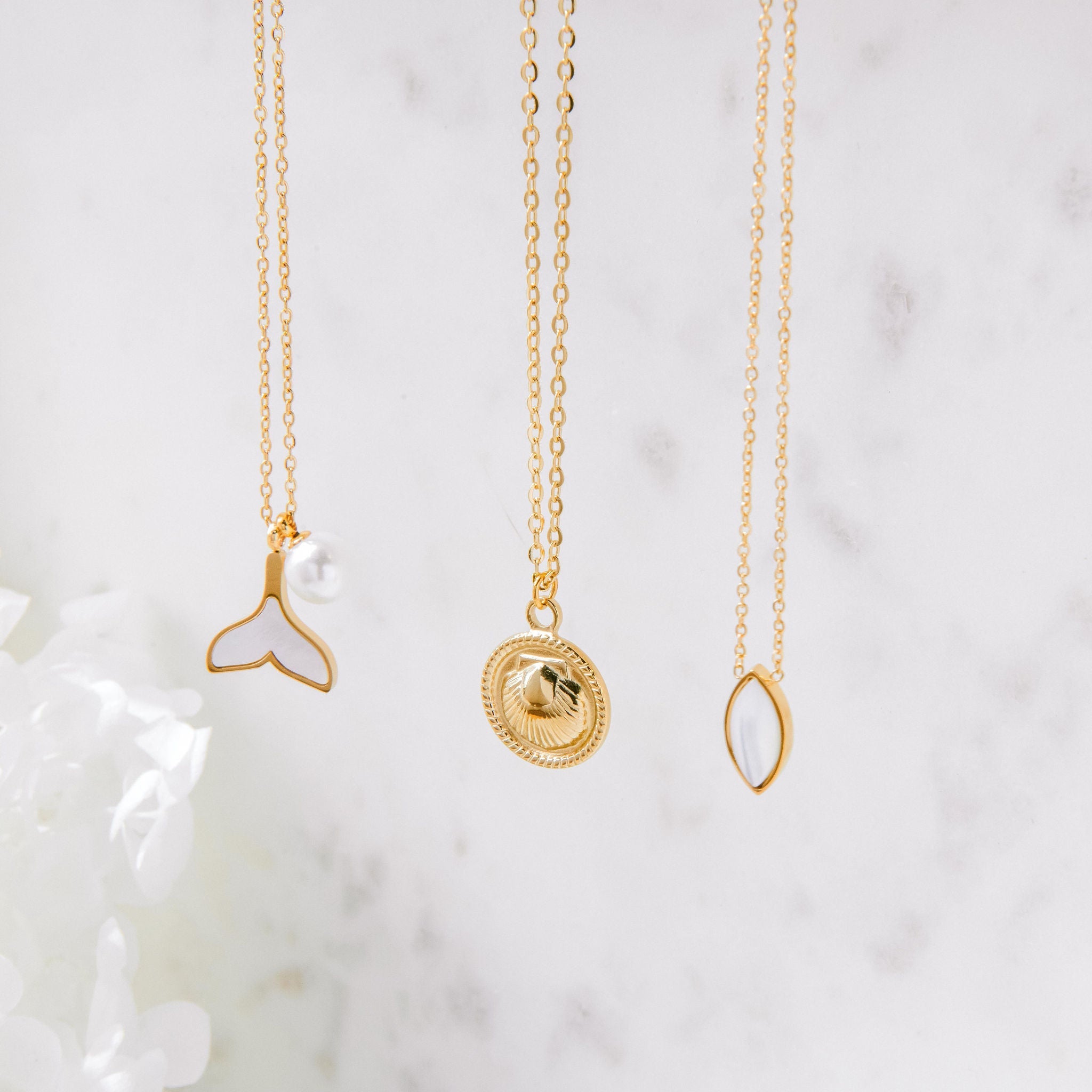 Gold whale tail necklace with mother of pearl inlay and freshwater pearl charm on waterproof chain