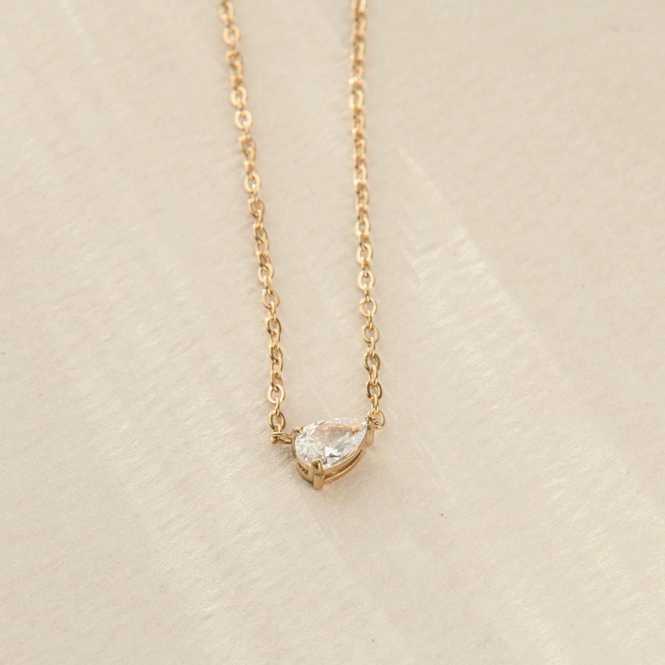 gold necklace with pear-cut cubic zirconia pendant on fine chain