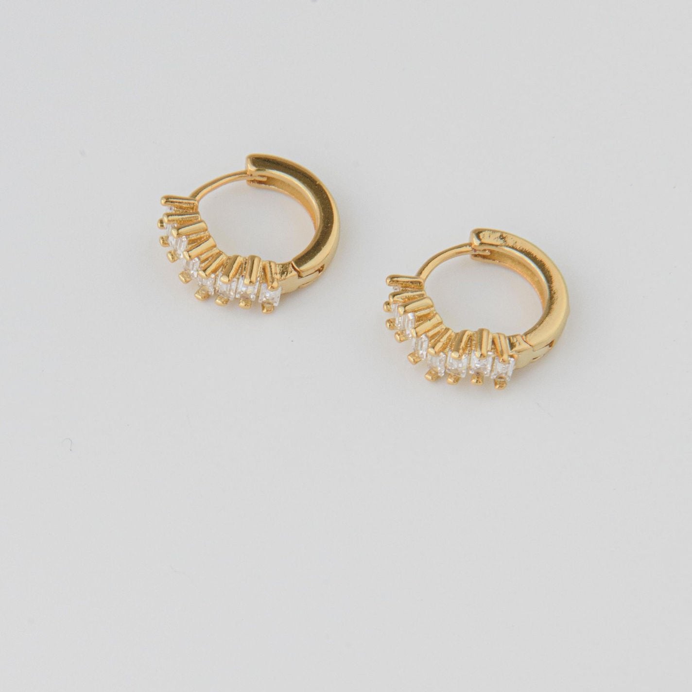 gold huggie earrings with baguette cubic zirconia stones