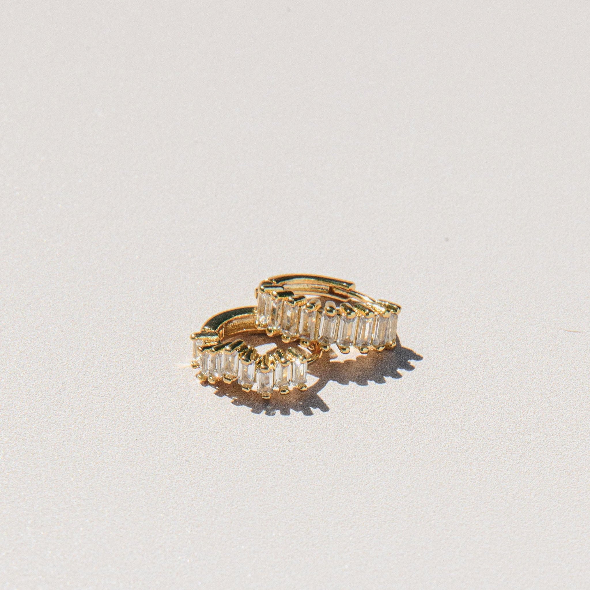 gold huggie earrings with baguette cubic zirconia stones