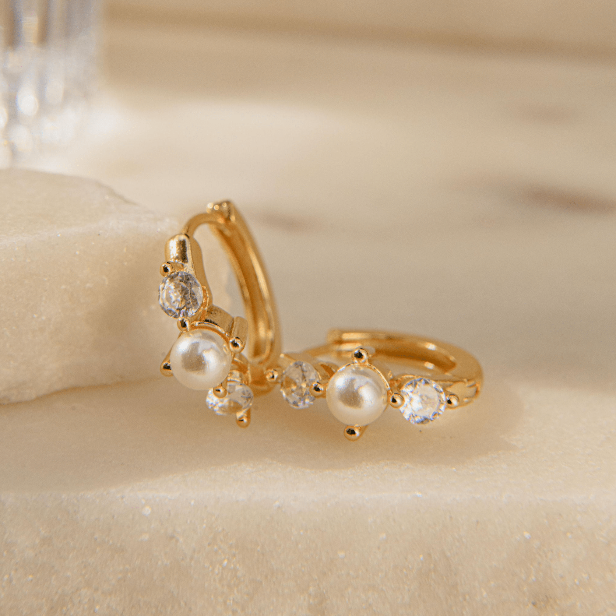 Gold huggie earrings with freshwater pearl and Cubic Zirconia stones in a waterproof setting
