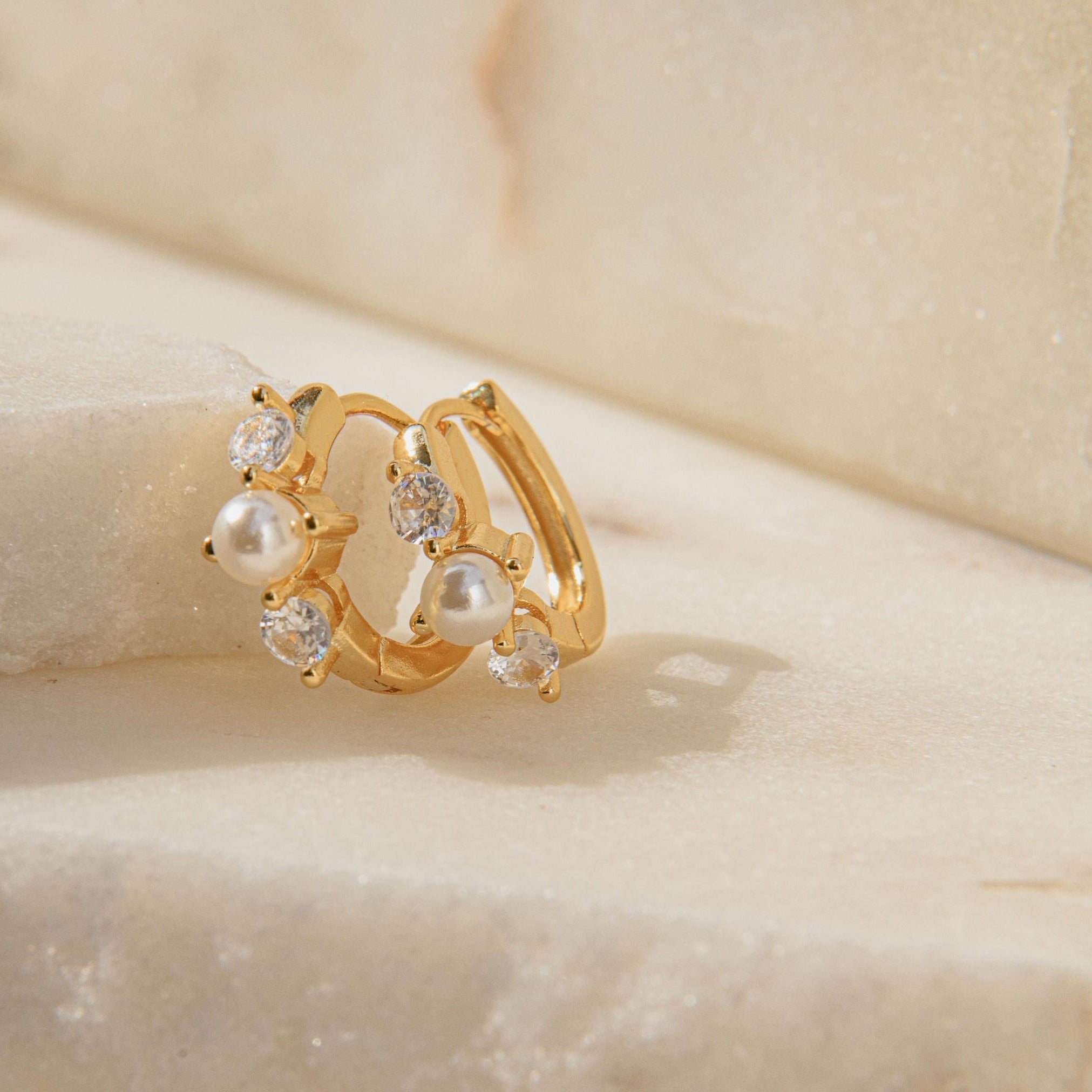 Gold huggie earrings with freshwater pearl and Cubic Zirconia stones in a waterproof setting