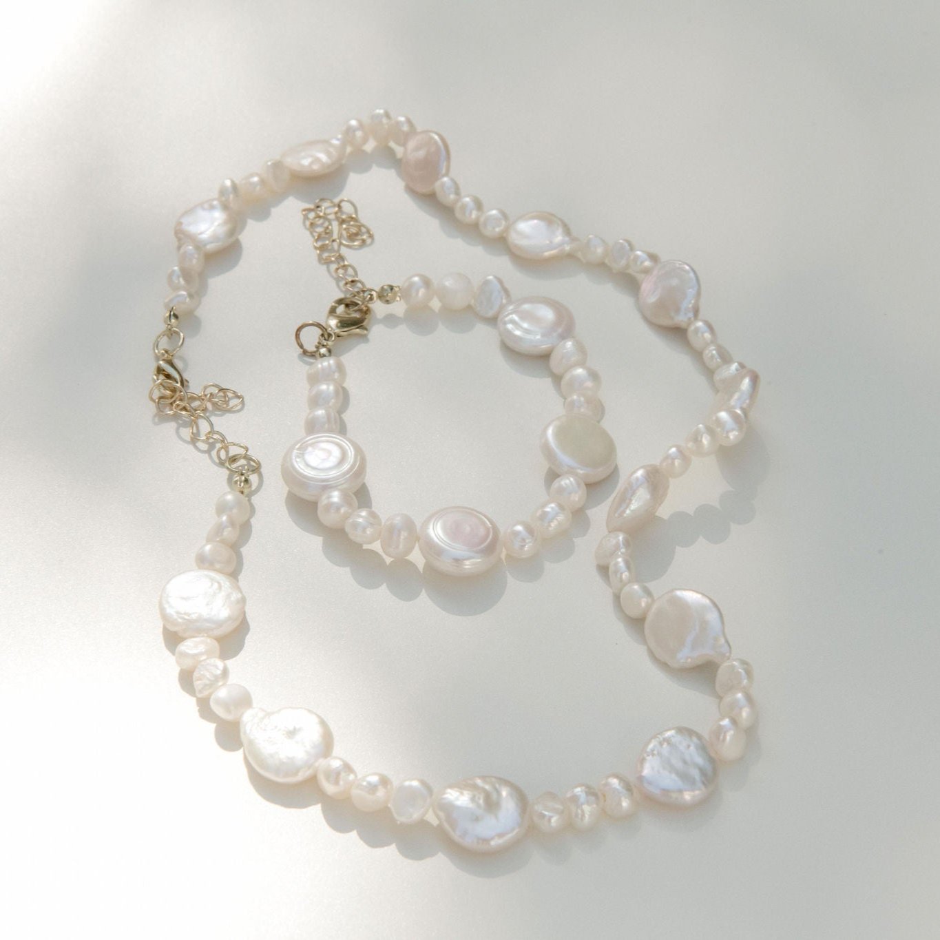Freshwater pearl necklace featuring coin pearls and organic shapes with a waterproof gold clasp