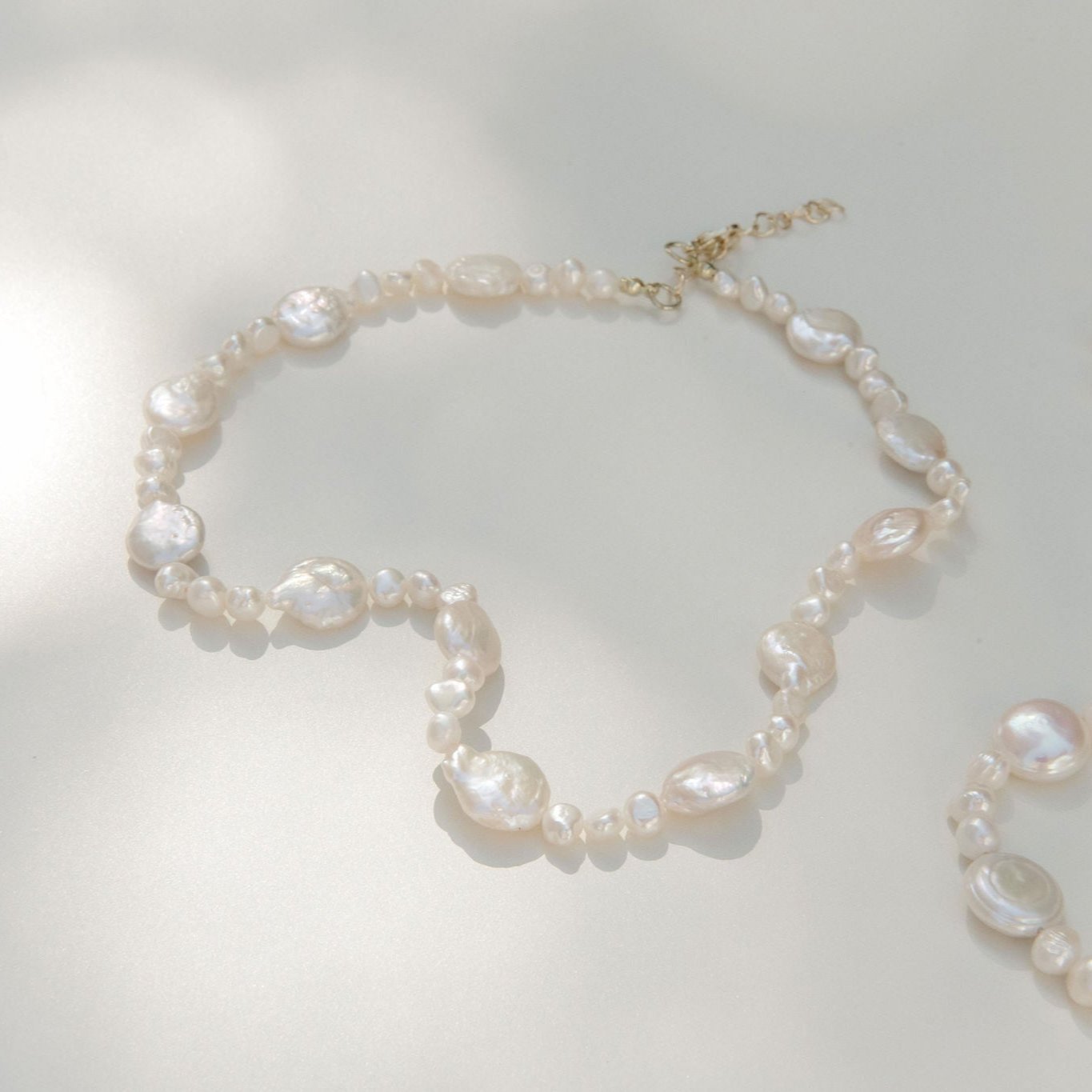 Freshwater pearl necklace featuring coin pearls and organic shapes with a waterproof gold clasp