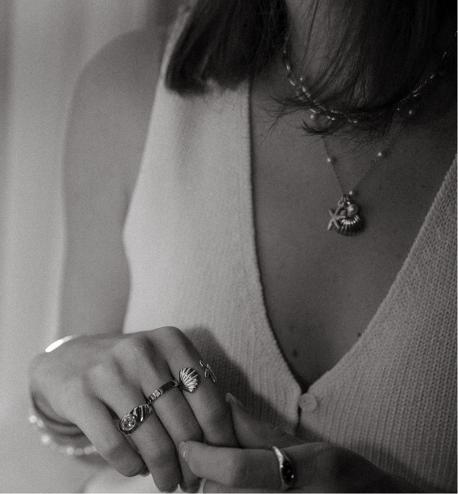 Marina Necklace with gold starfish and shell charms and freshwater pearl accents on a waterproof chain