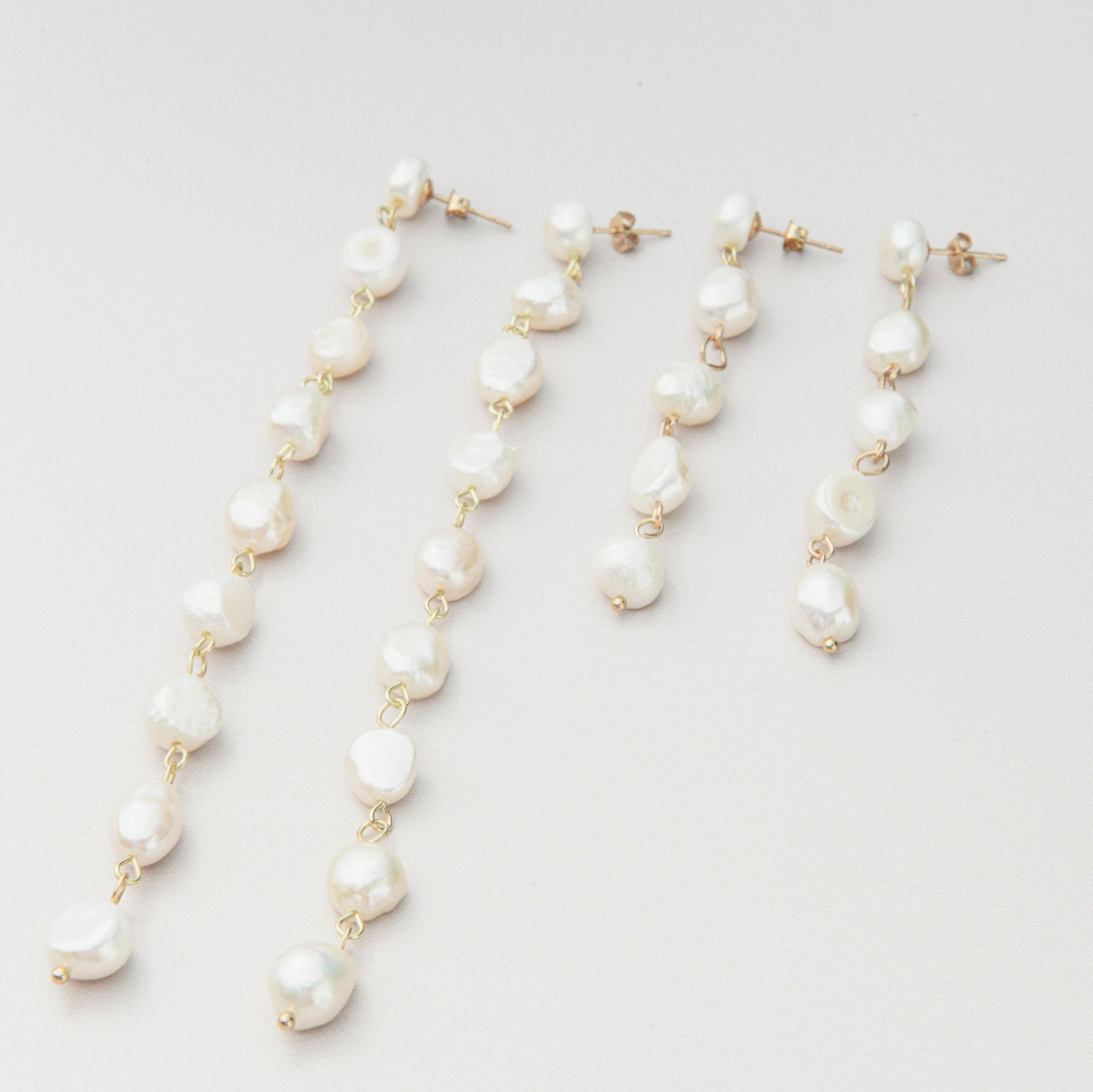 Long freshwater pearl drop earrings with delicate gold setting and cascading design