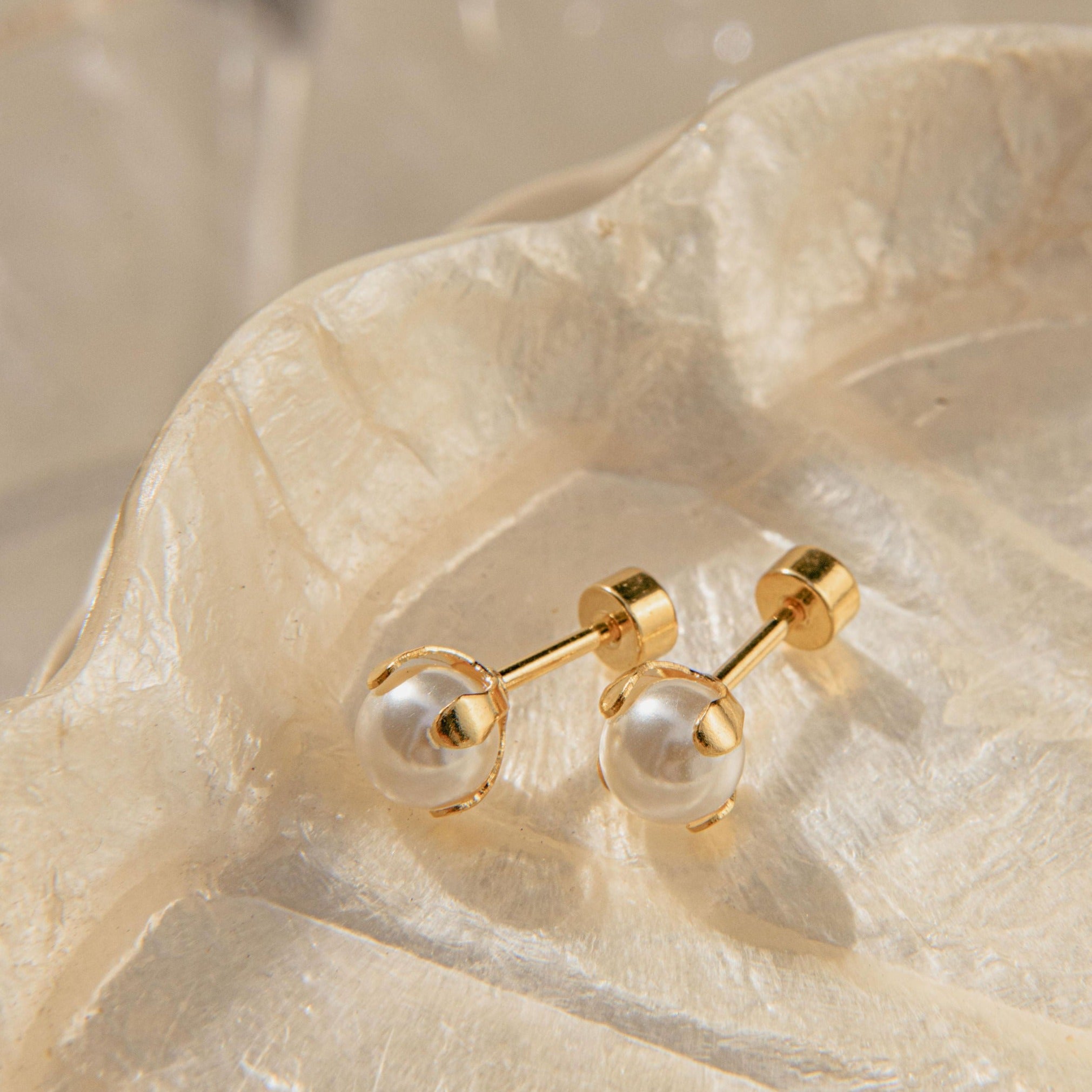Delicate gold pearl earrings with four-claw setting and freshwater pearls in a ballback stud design