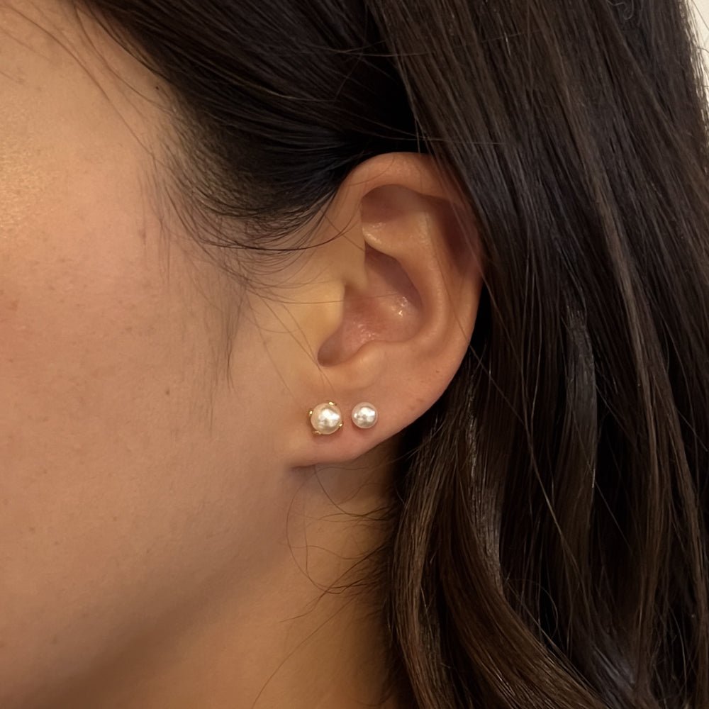 Delicate gold pearl earrings with four-claw setting and freshwater pearls in a ballback stud design