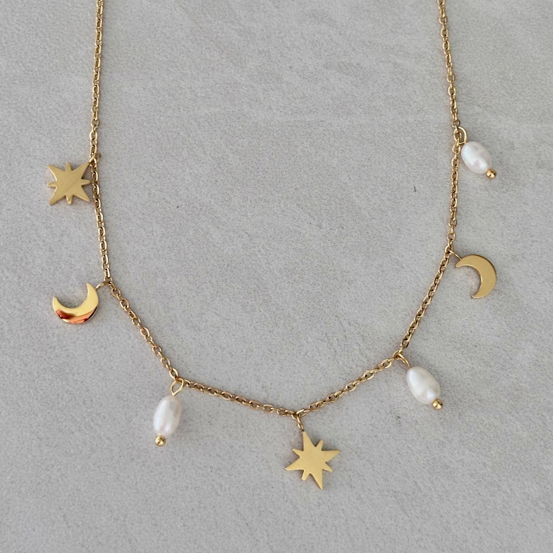 Gold pearl necklace with freshwater pearls and celestial star and moon charms on a waterproof gold chain