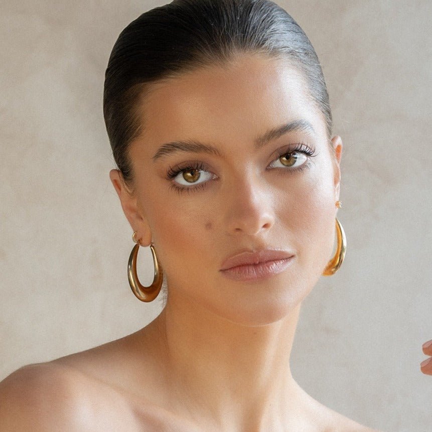 Chunky gold hoop earrings with sculptural teardrop shape