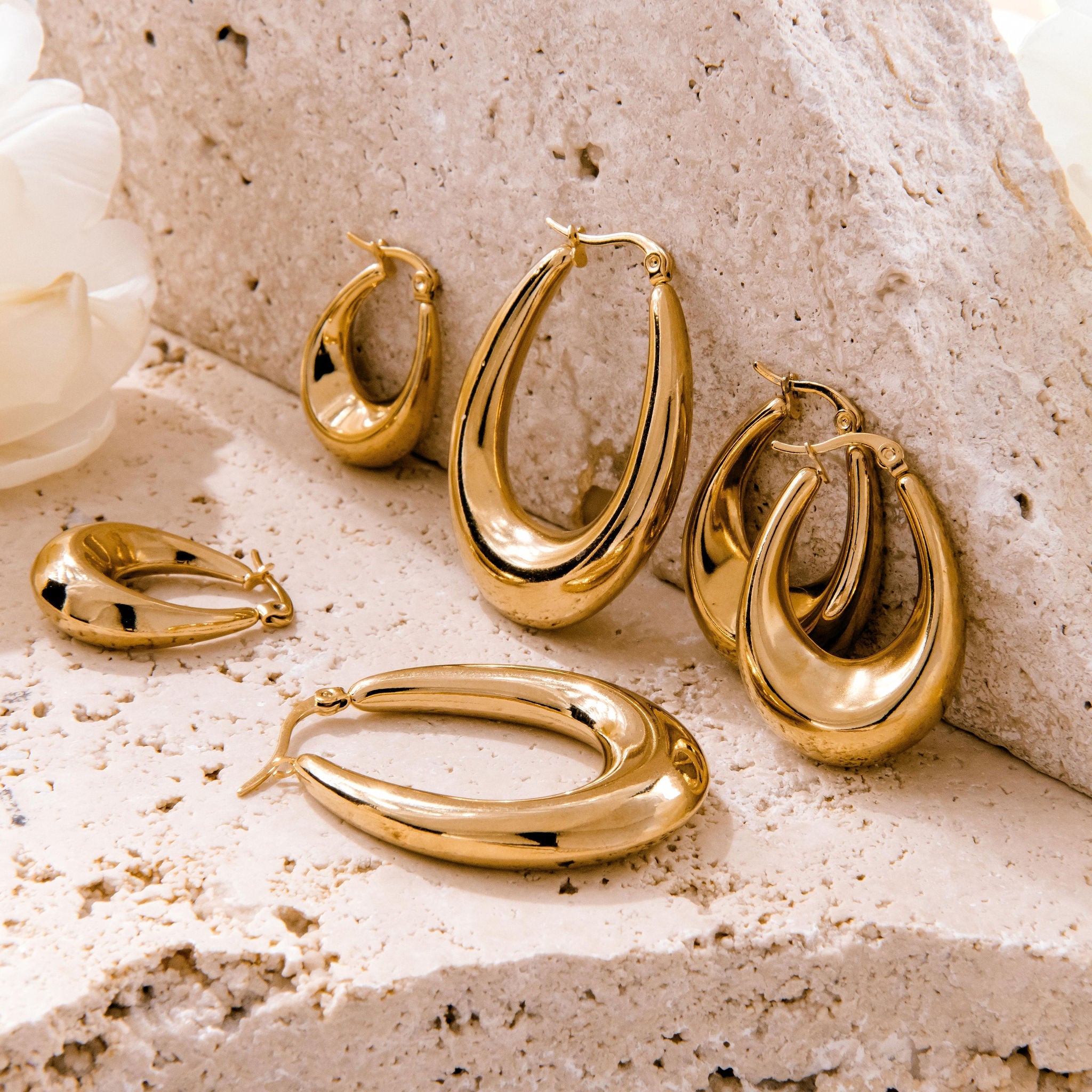 Small gold hoop earrings with teardrop shape and high-polish finish
