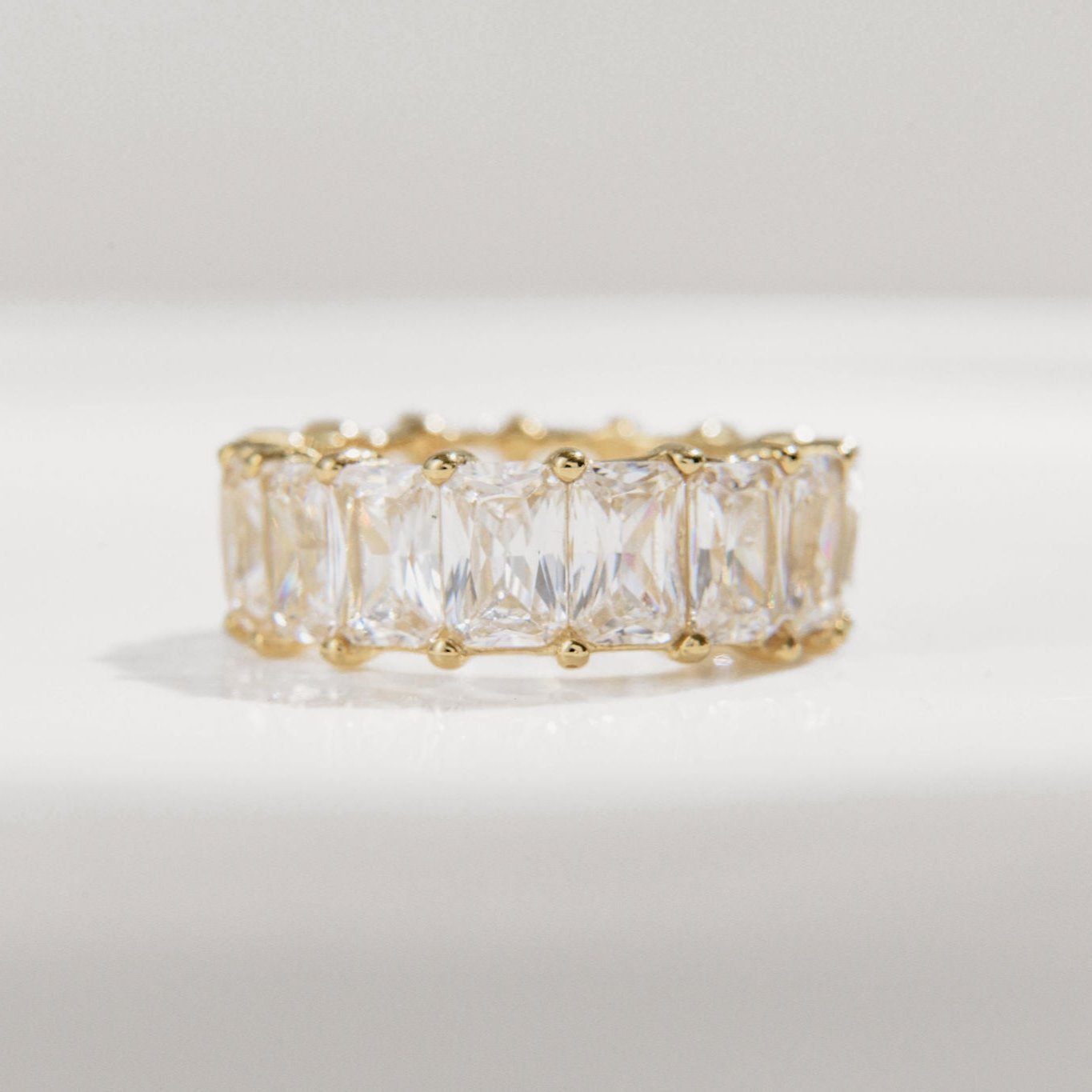 gold band ring with radiant-cut Cubic Zirconia stones in prong settings