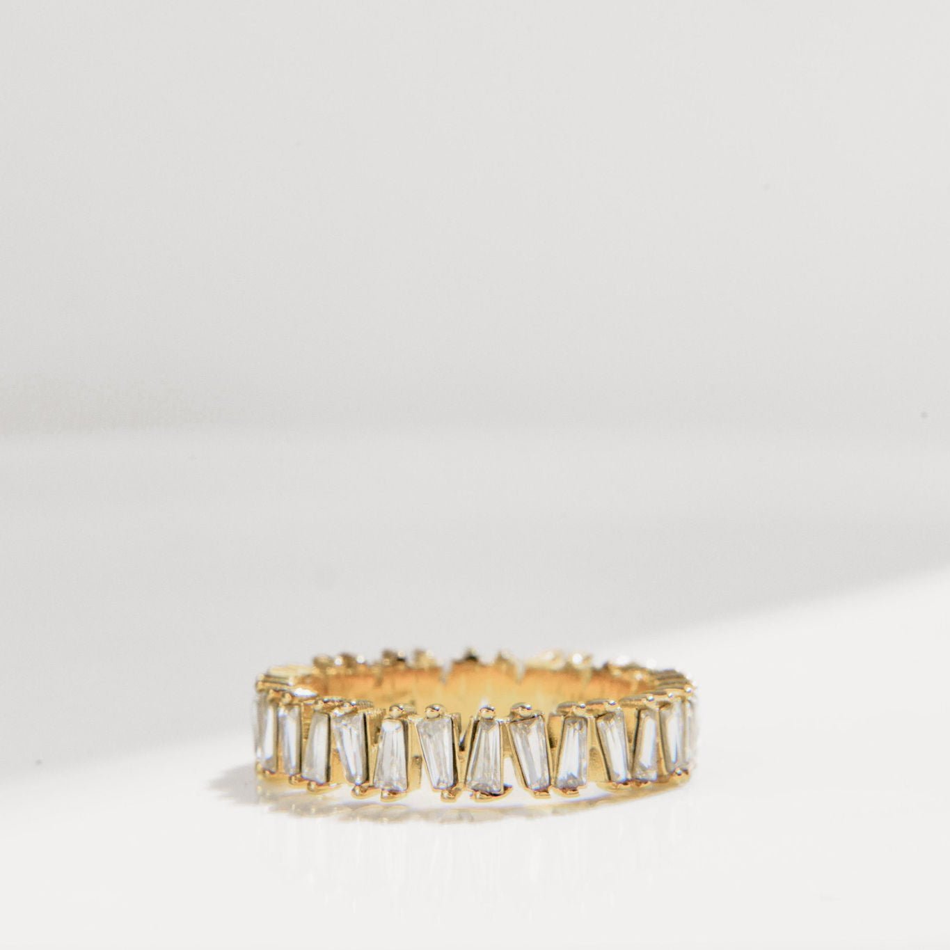 gold ring with baguette-cut Cubic Zirconia stones in a full band setting