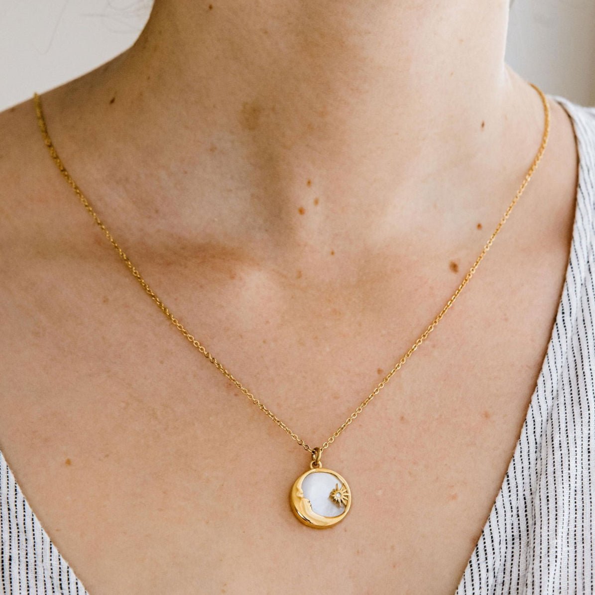 Gold moon and star pendant necklace with mother of pearl inlay and Cubic Zirconia detail on a waterproof chain