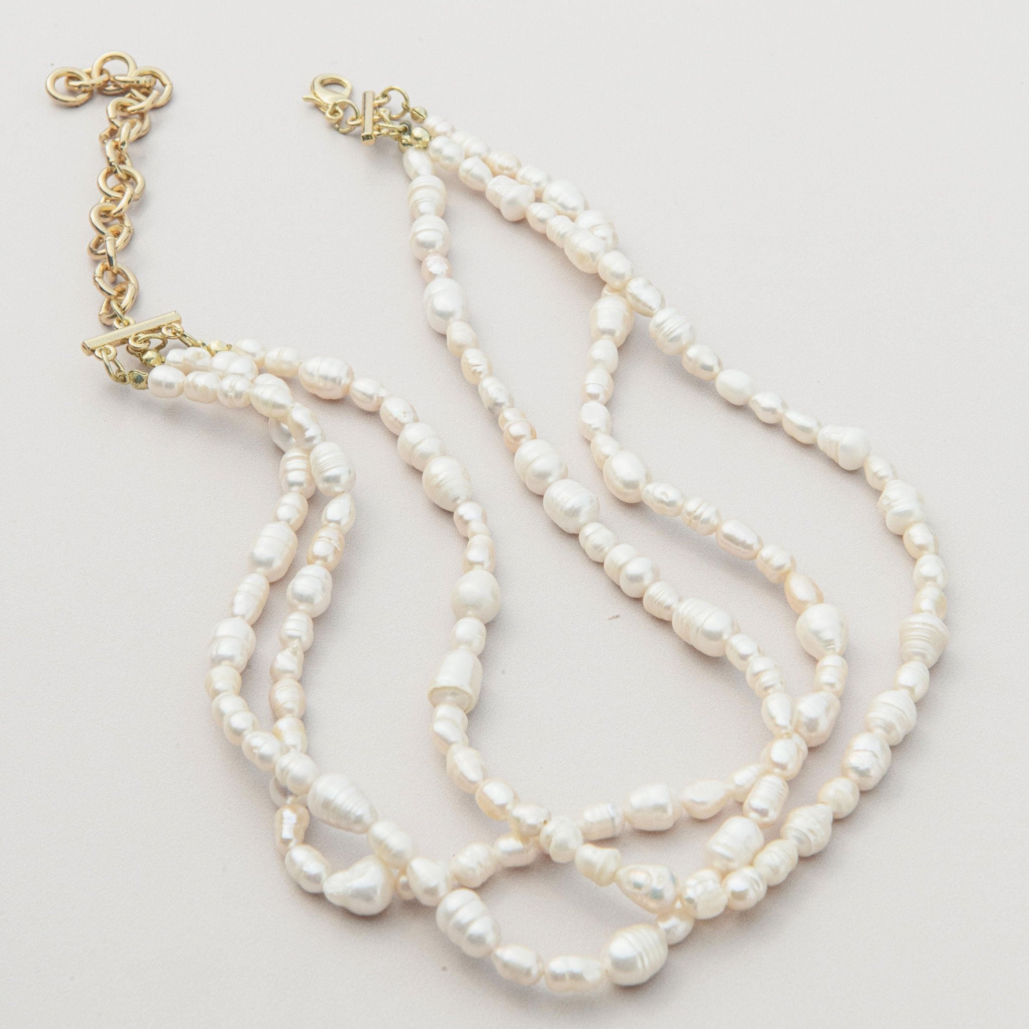 Triple strand freshwater pearl necklace with organic shapes and a waterproof gold clasp