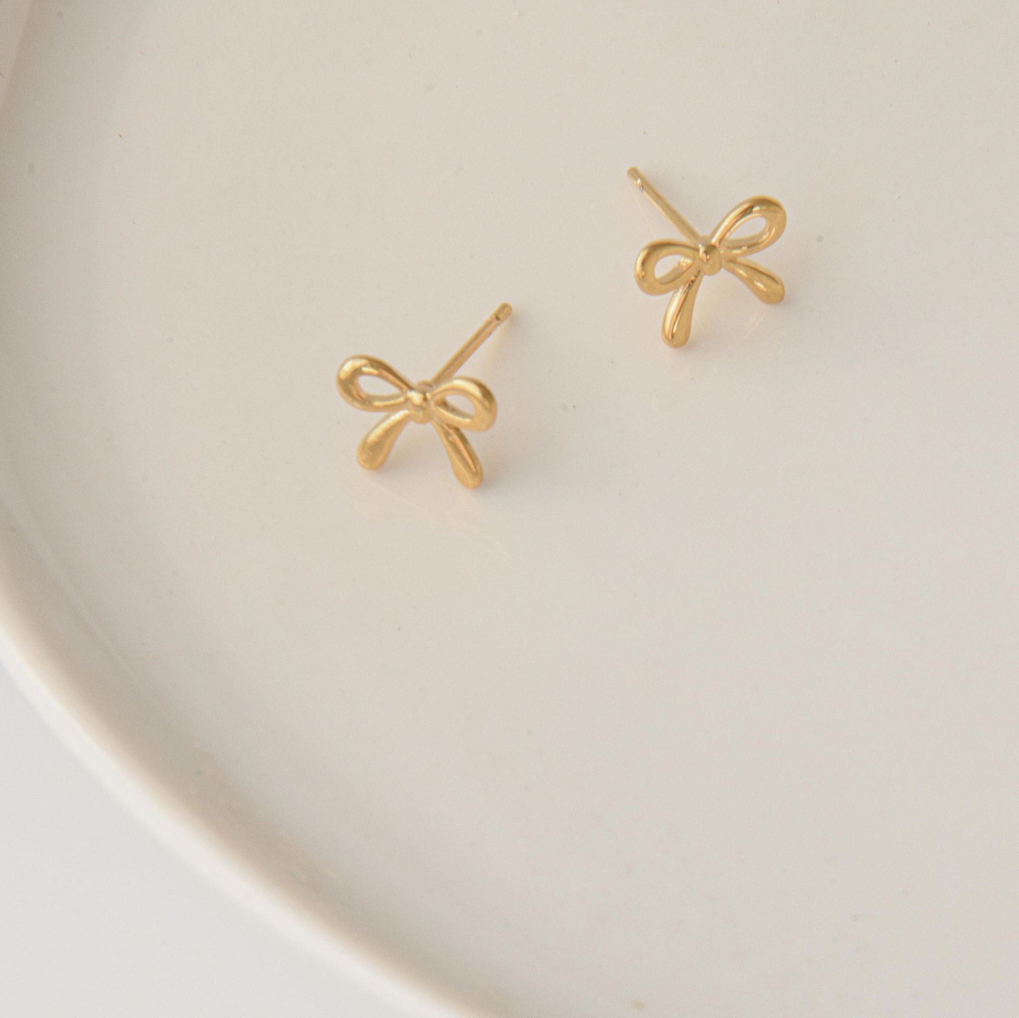 gold bow earrings with delicate stud earrings design