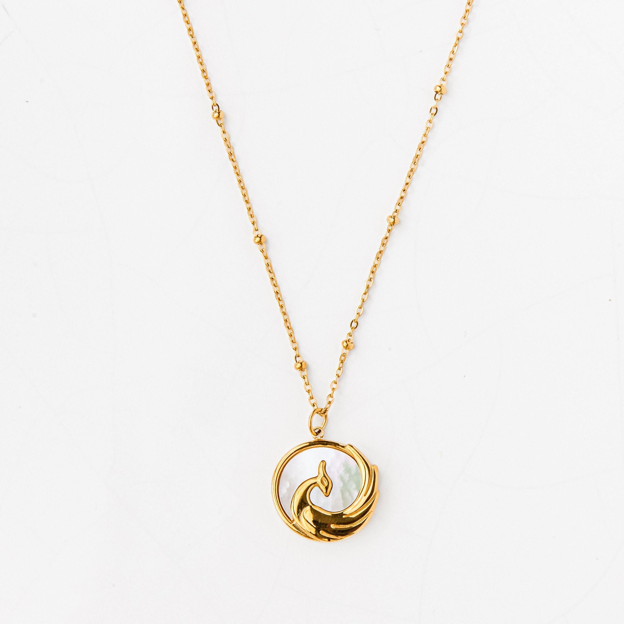 Gold phoenix pendant necklace on waterproof beaded chain symbolising rebirth and strength