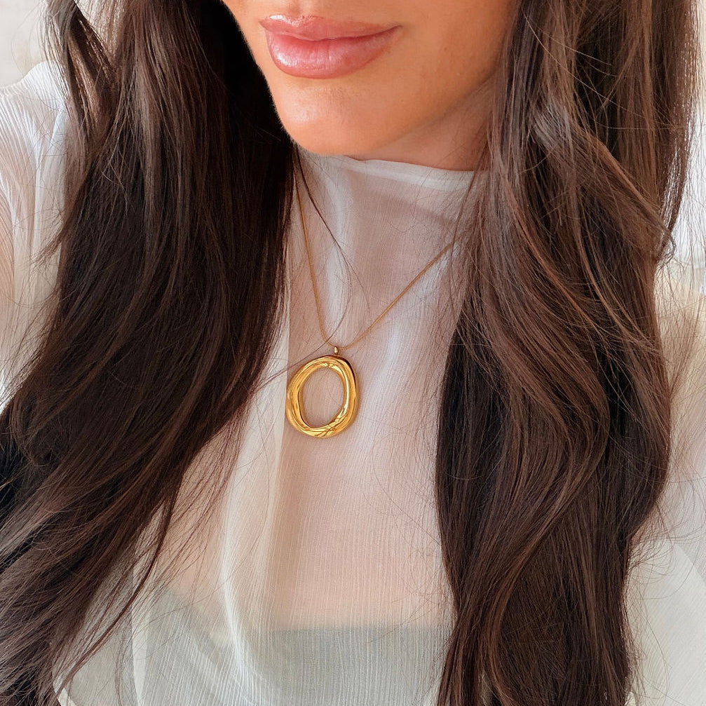 Kyra gold pendant necklace with a polished organic open-centre design