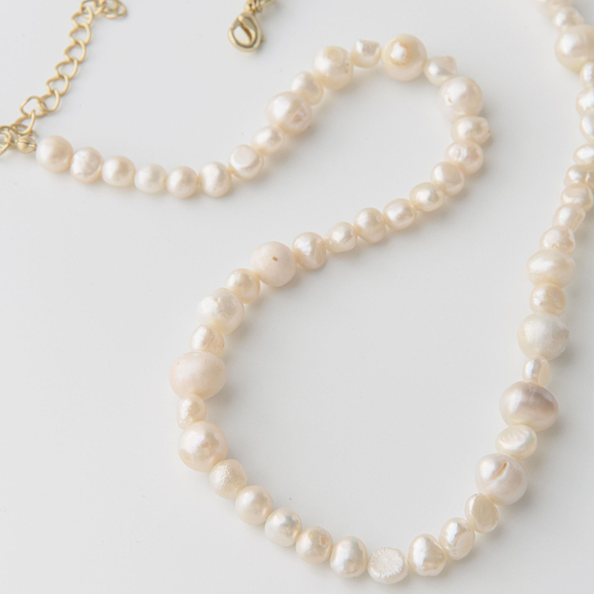 Freshwater pearl necklace featuring organic pearl shapes and a waterproof gold clasp