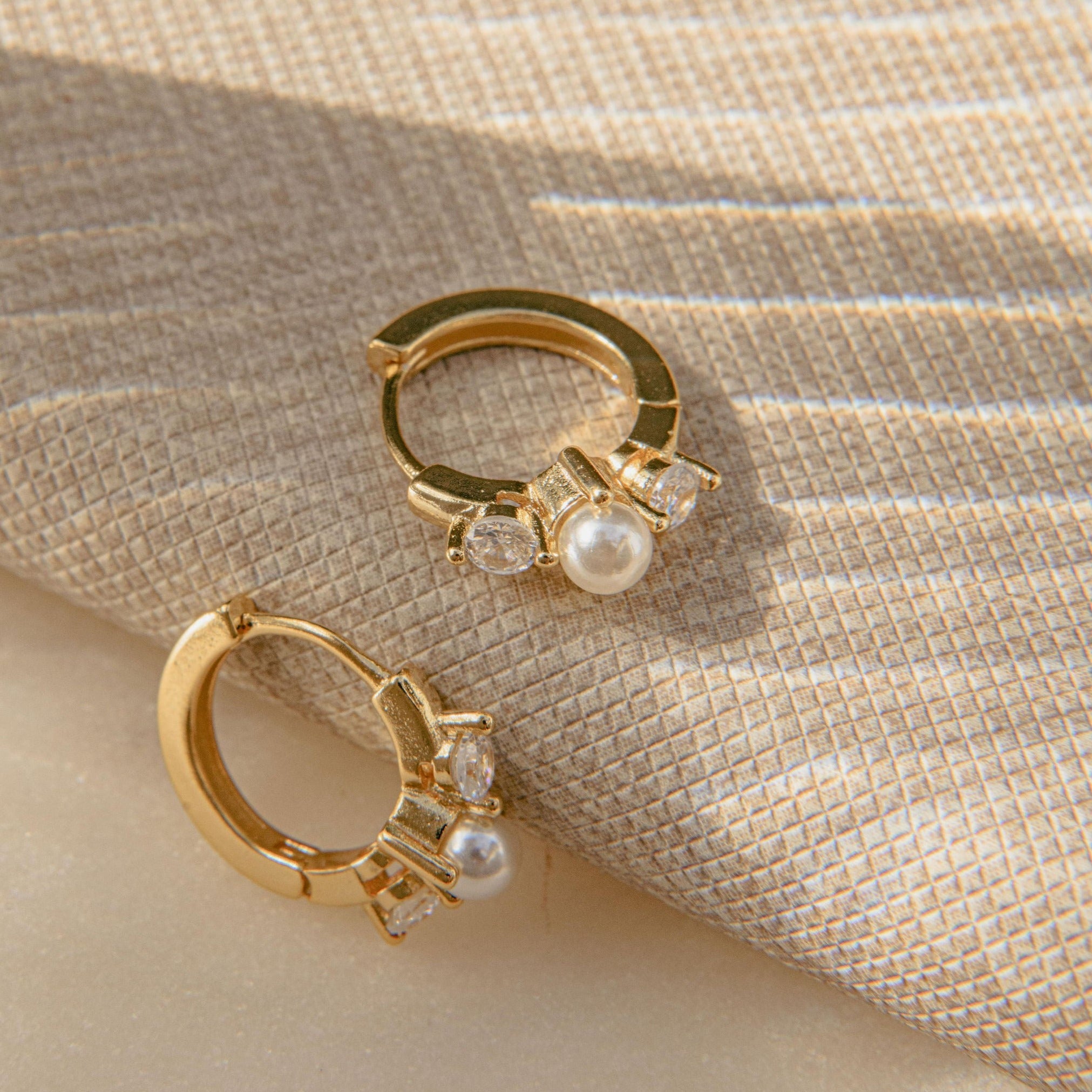 Gold huggie earrings with freshwater pearl and Cubic Zirconia stones in a waterproof setting