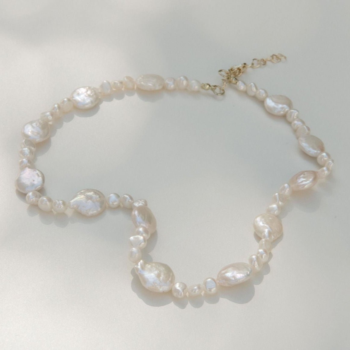 Freshwater pearl necklace featuring coin pearls and organic shapes with a waterproof gold clasp