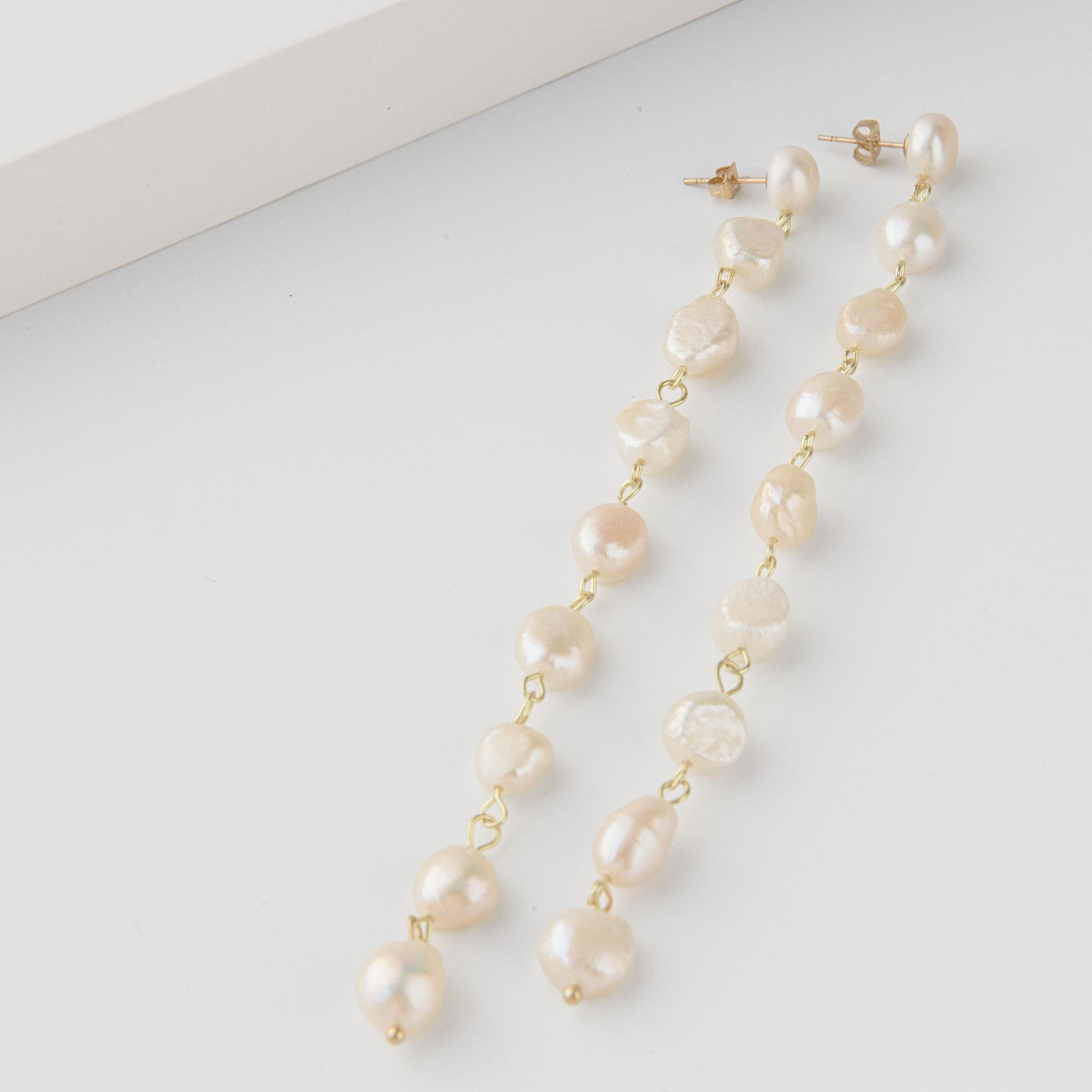Long freshwater pearl drop earrings with delicate gold setting and cascading design