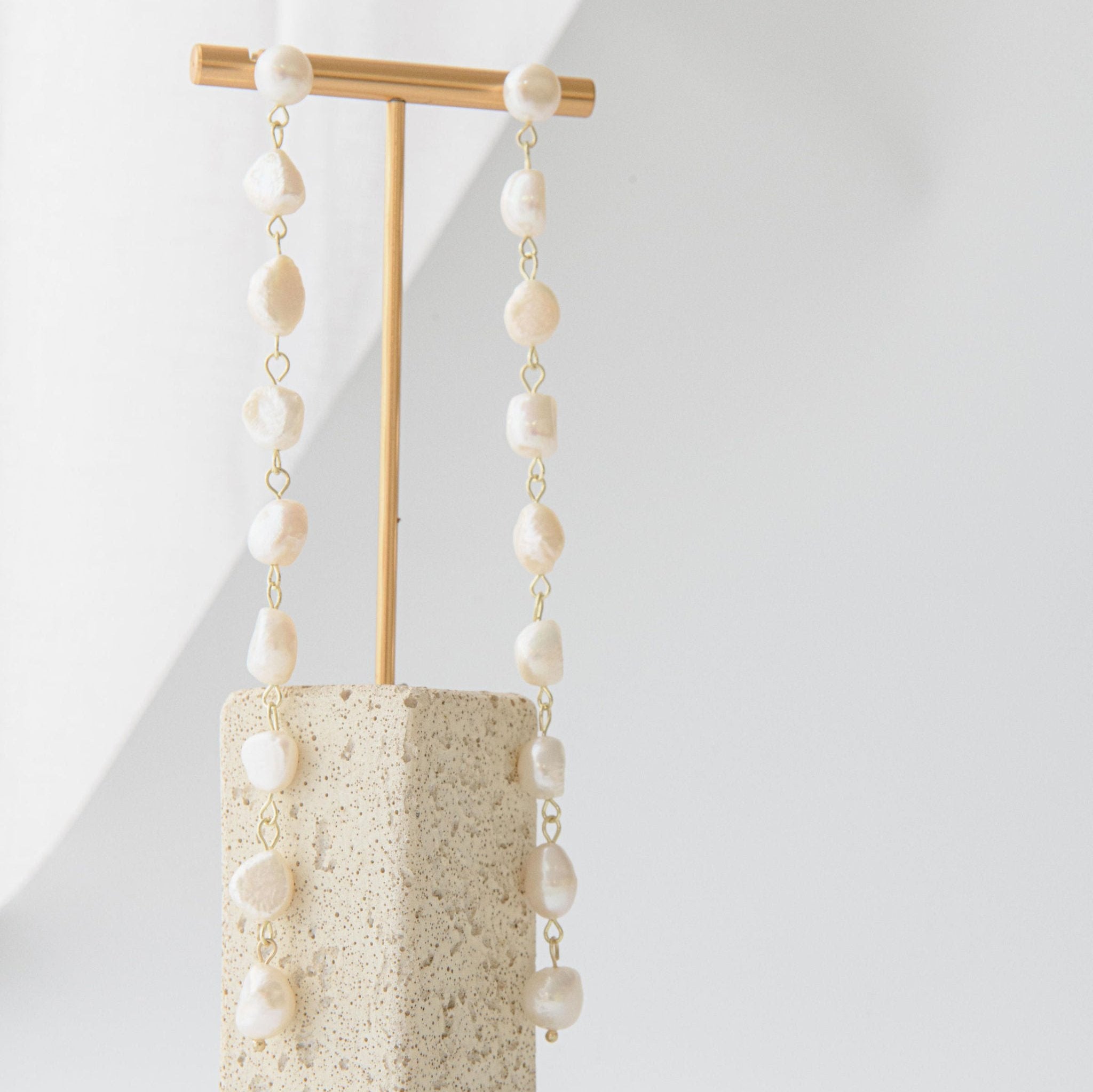 Long freshwater pearl drop earrings with delicate gold setting and cascading design