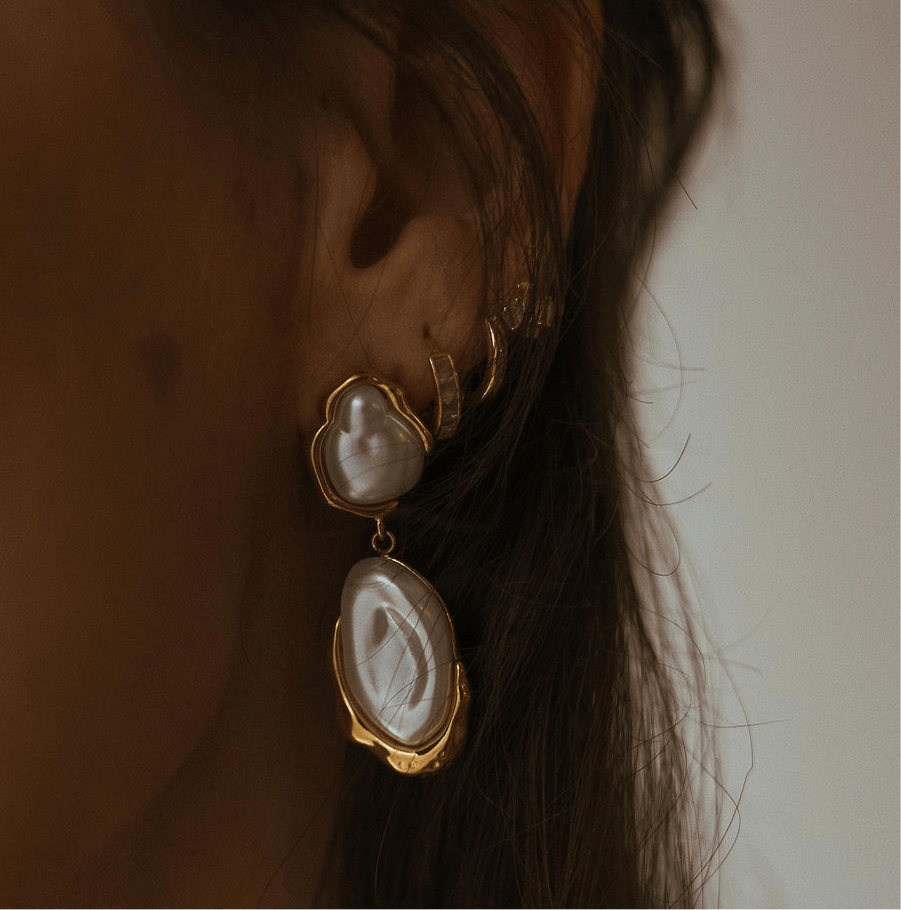 Solara pearl drop earrings featuring natural freshwater pearls framed in waterproof gold with an organic, sculptural design.