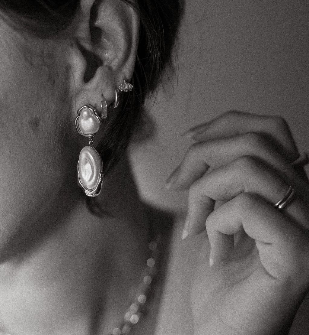 Solara pearl drop earrings featuring natural freshwater pearls framed in waterproof gold with an organic, sculptural design.